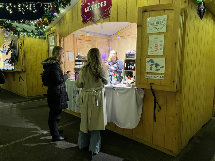 Two shoppers chatting with the farm at the Christmas market booth