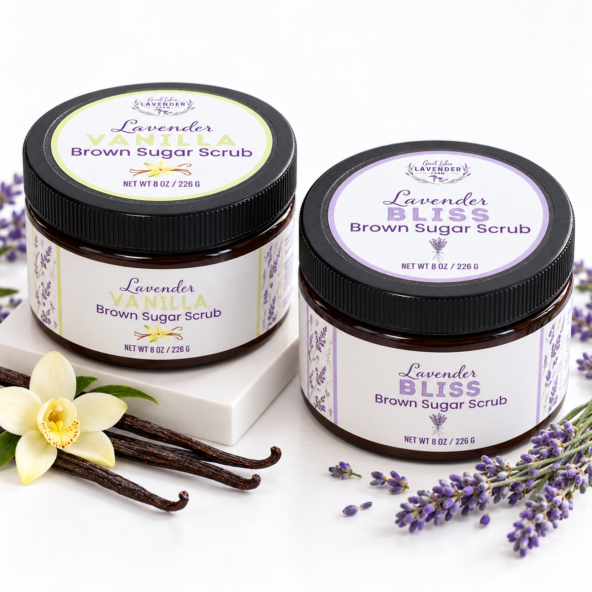 Lavender Vanilla and Lavender Bliss Brown Sugar Scrub jars with vanilla beans, a vanilla flower and lavender