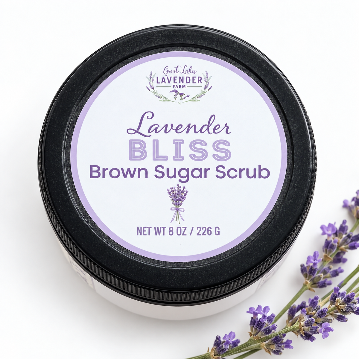 Lavender Bliss Brown Sugar Scrub jar lid, top view, beside lavender sprigs on white