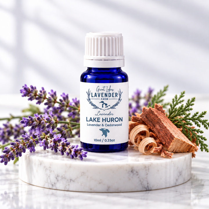 Lavender Lake Huron Essential Oil 10 ml blue bottle on a marble round with lavender and cedar
