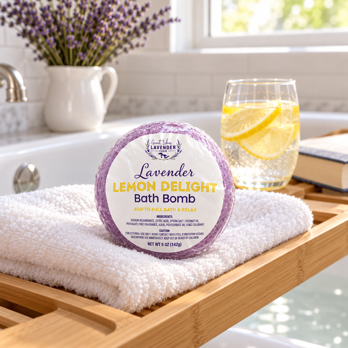 Lavender Lemon Delight Bath Bomb on a towel on a bath caddy with a glass of lemon water