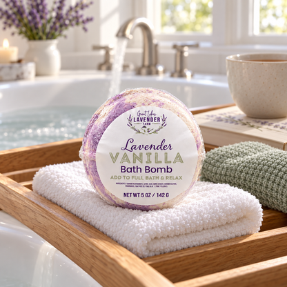 Lavender Vanilla Bath Bomb on a folded white towel atop a wooden bath tray over a tub, with a mug nearby
