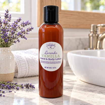 Lavender Vanilla Hand & Body Lotion on a bathroom counter by a vessel sink with lavender in a vase and towels
