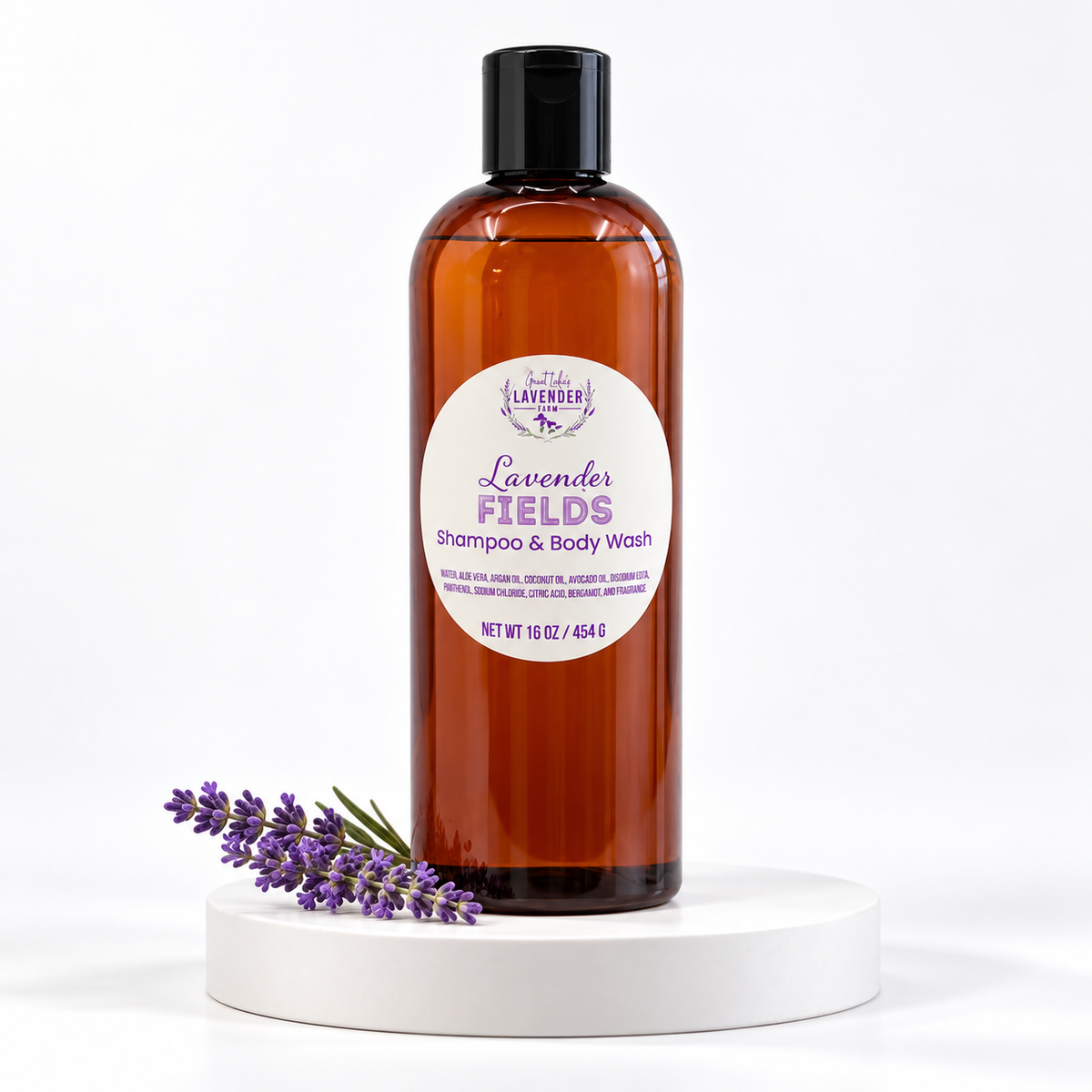 Lavender Fields Shampoo & Body Wash amber bottle on a white round stand with a lavender sprig