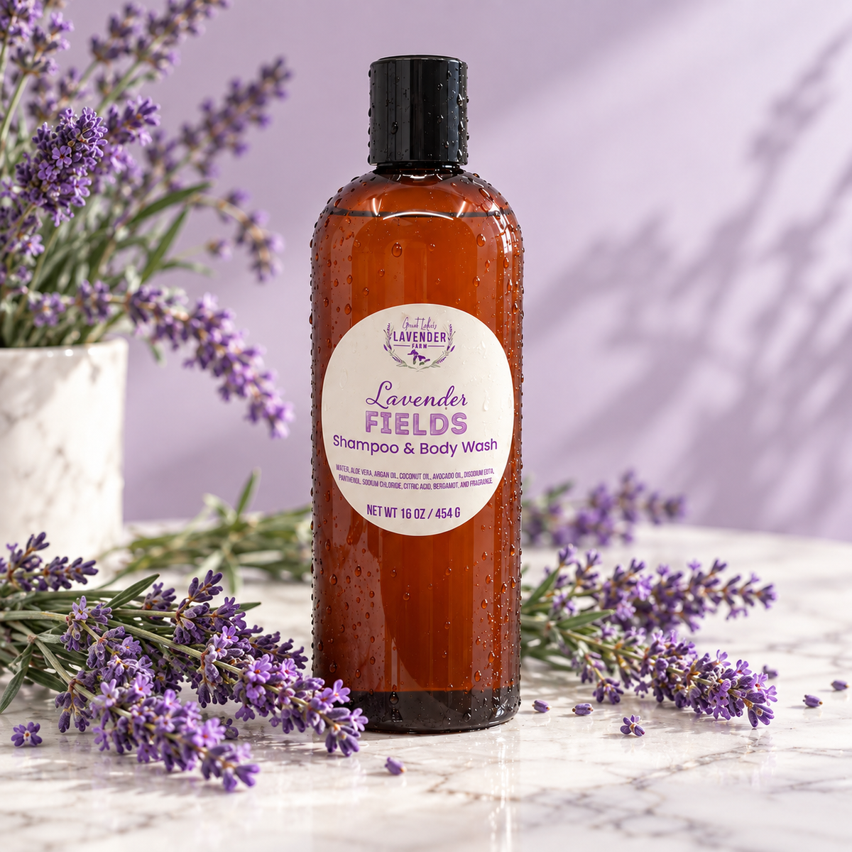 Lavender Fields Shampoo & Body Wash amber bottle on a marble counter surrounded by fresh lavender