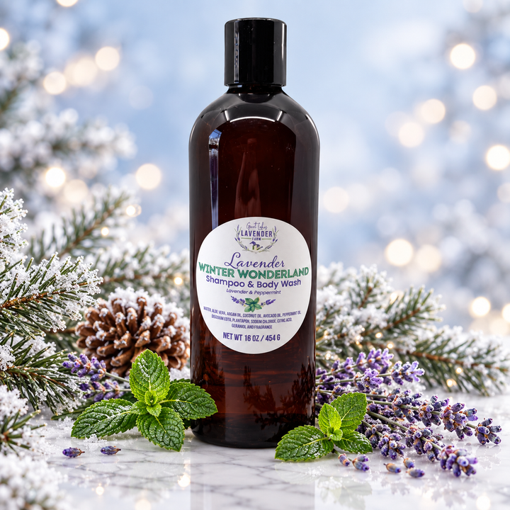 Lavender Winter Wonderland Shampoo and Body Wash bottle standing on a surface surrounded by lavender, mint leaves, pine cones