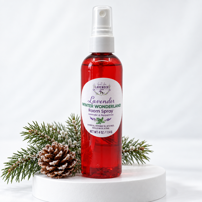 Winter Wonderland room spray in a red bottle on a white pedestal with pine