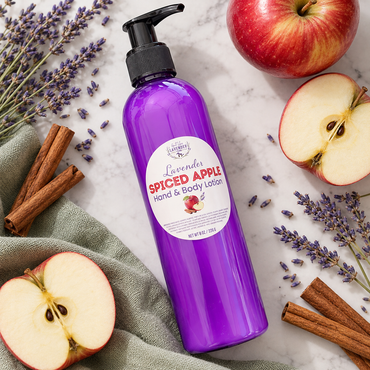Lavender Spiced Apple Hand & Body Lotion lying on marble with apple halves, cinnamon sticks and lavender sprigs