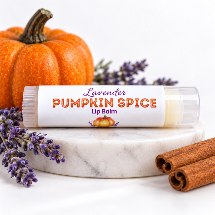 Lavender Pumpkin Spice Lip Balm tube on a marble riser with a pumpkin, cinnamon and lavender