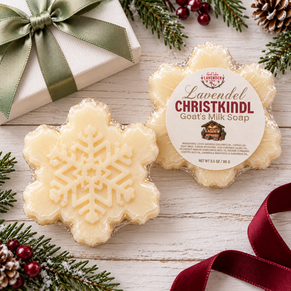 Christkindl goat's milk soaps beside a gift box with green ribbon