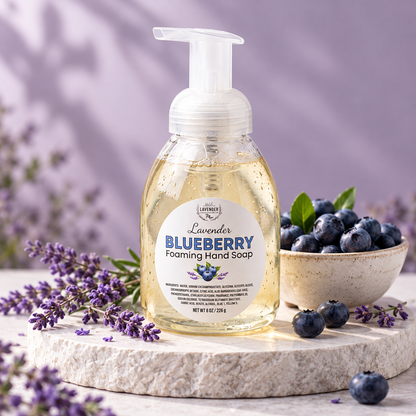 Lavender Blueberry Foaming Hand Soap on a stone riser with a bowl of blueberries and lavender