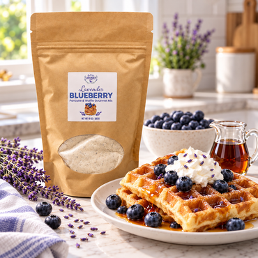Lavender Blueberry Pancake & Waffle Mix pouch beside a waffle topped with whipped cream and blueberries