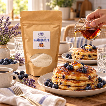 Syrup poured over blueberry pancakes beside a pouch of Lavender Blueberry Pancake & Waffle Mix