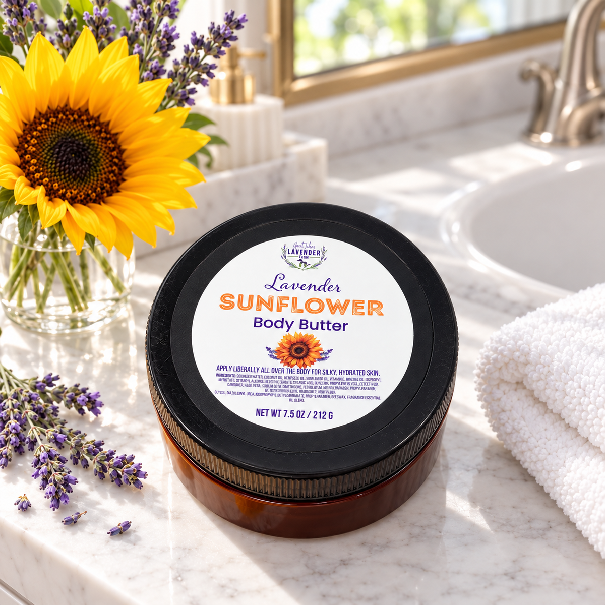 Lavender Sunflower Body Butter on a marble bathroom counter with a sunflower in a vase and a towel