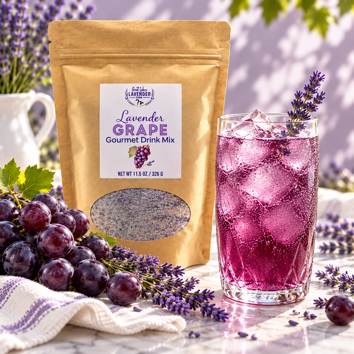 Lavender Grape Gourmet Drink Mix pouch beside a tall glass of iced purple grape drink and fresh grapes