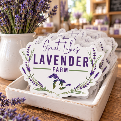 Great Lakes Lavender Farm Logo Vinyl Waterproof Stickers stacked in a white tray beside a lavender vase