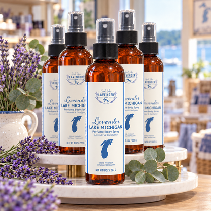 Several Lavender Lake Michigan Perfume Body Sprays on a marble riser with lavender and eucalyptus