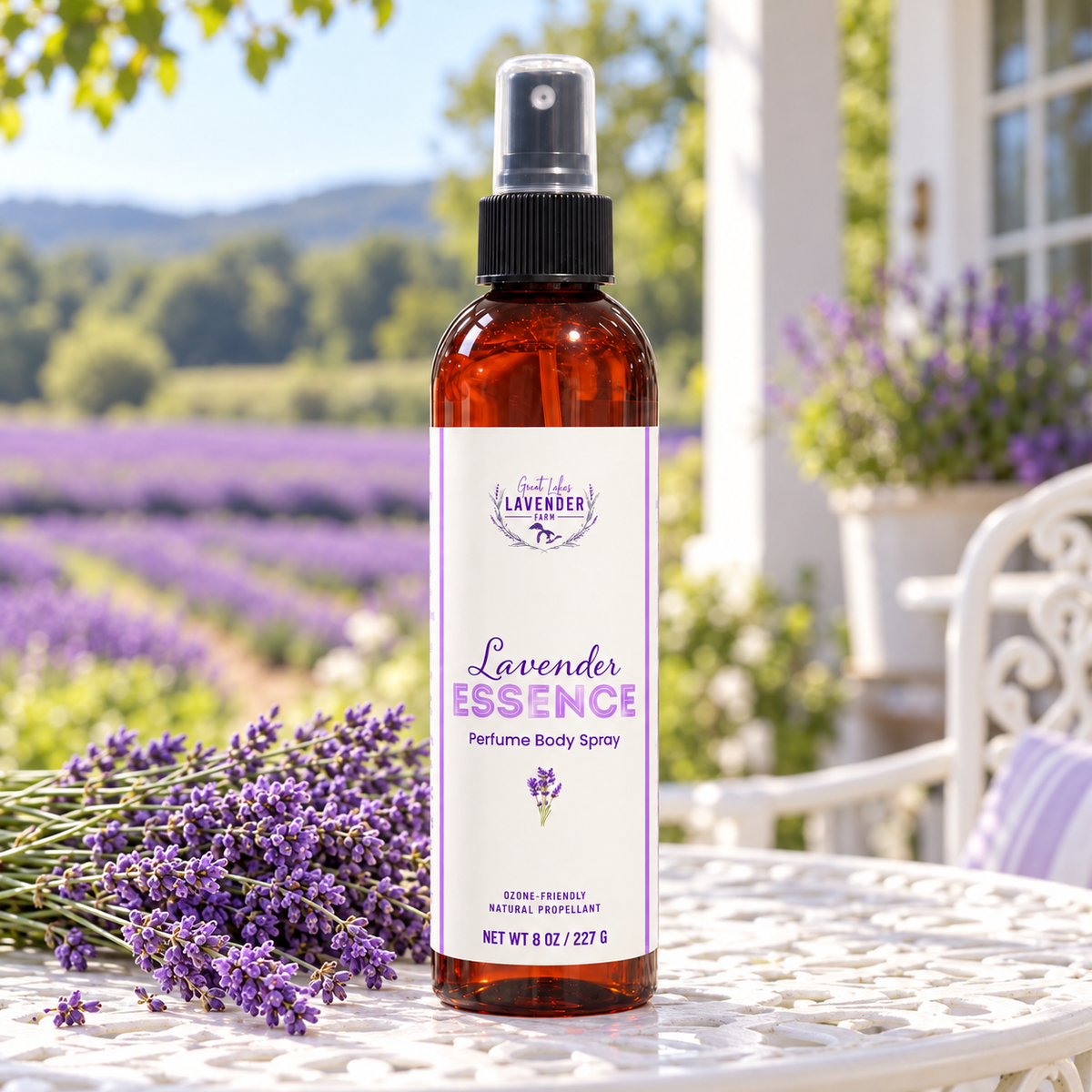 Lavender Essence Perfume Body Spray bottle on a porch table overlooking rows of blooming lavender