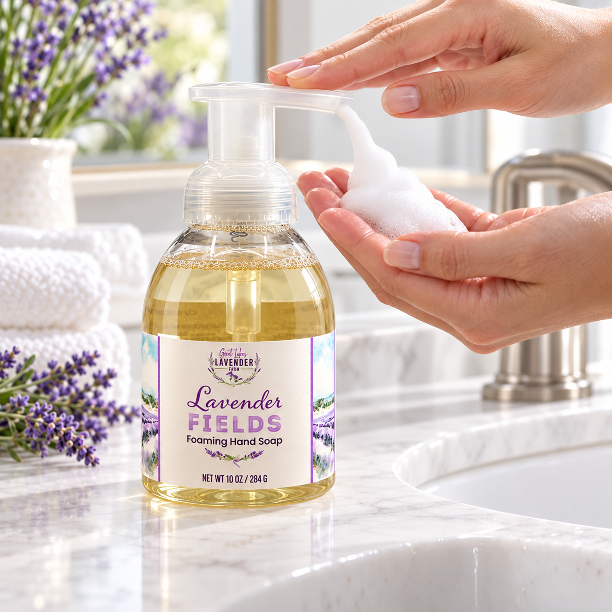 Hand pumping foam from a Lavender Fields Foaming Hand Soap bottle at a bathroom sink