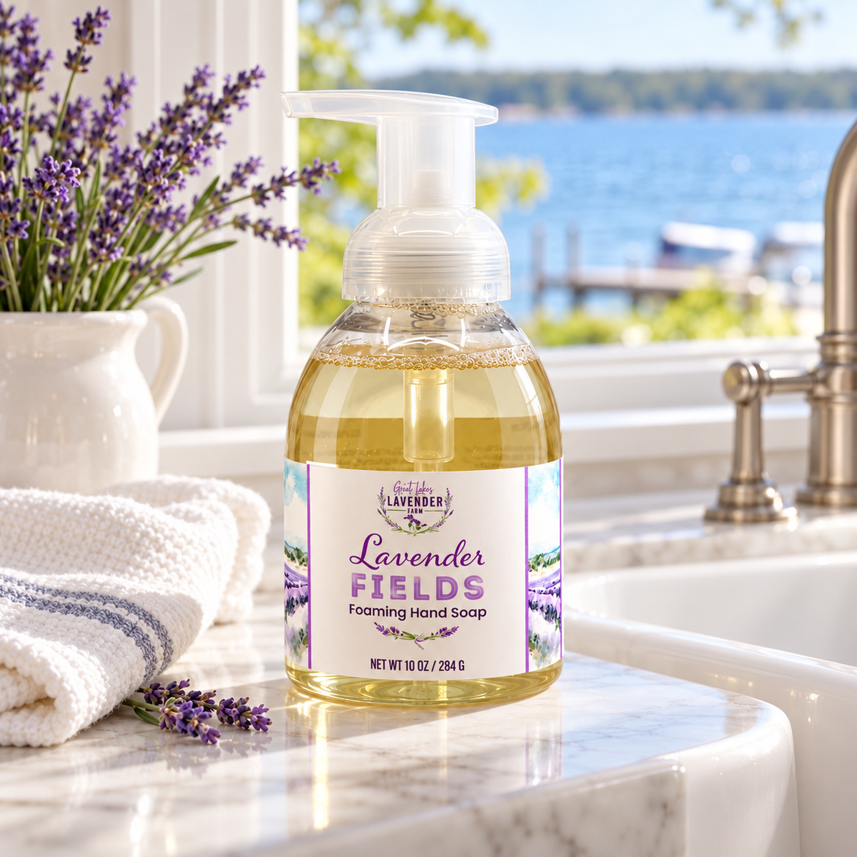 Lavender Fields Foaming Hand Soap bottle on a bathroom counter by a window with a lake view