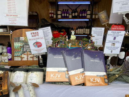 Christmas market table with free Bibles and a Jesus Saves sign