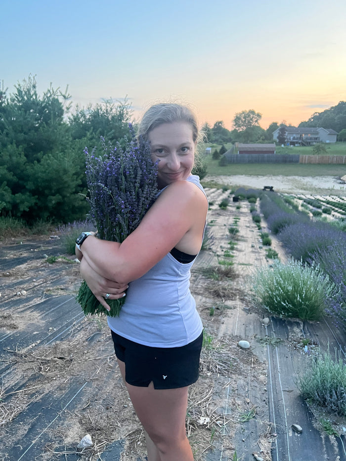 Woman hugging a bundle of lavender at dusk