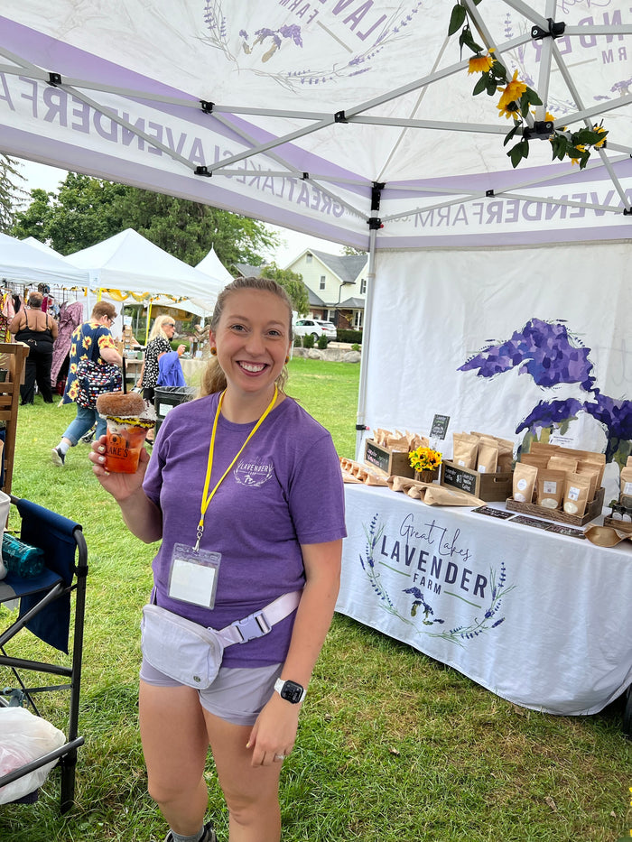 Woman at the booth holding a drink topped with a donut
