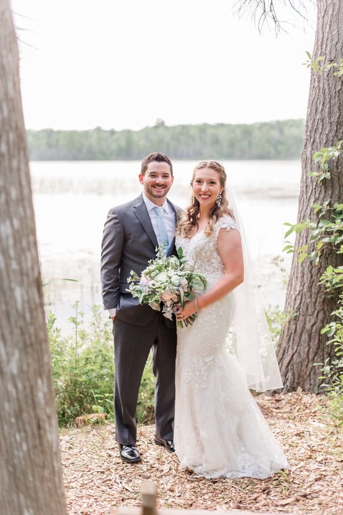 Sierra and Andrew on their wedding day by a lake