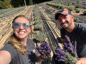 Sierra and Andrew smiling with fresh lavender in the field