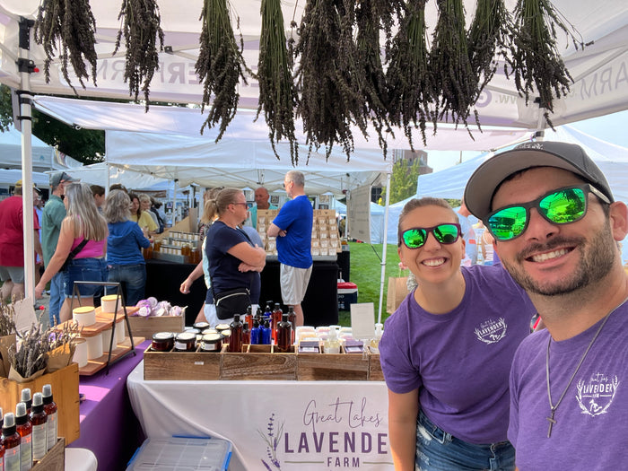 Selfie at the market booth with lavender bundles hanging from the tent
